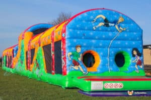 A large inflatable obstacle course, 'The Colossal', positioned on a grassy field, perfect for outdoor entertainment.