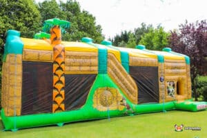 Large giant inflatable fun run designed with various jungle animals and lush greenery. For adults and children.