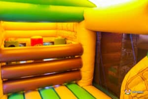 Jungle-themed bouncer with a slide, featuring ancient design, perfect for kids' outdoor fun and adventure.