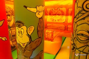 A colorful bouncy castle designed with a jungle theme, showcasing an biff and bash wobbler.