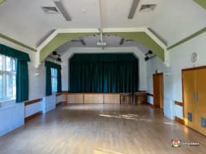 Large hall with wooden floor and stage area.