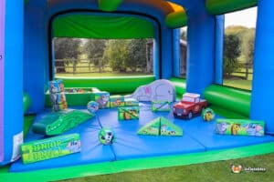 A soft play inflatable setup with a slide and toys, designed for safe and enjoyable play for children.