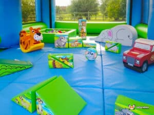 A colorful inflatable soft play area showcasing various toys and a small car for kids to play with.