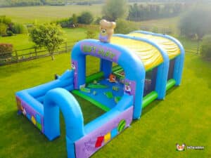A soft play inflatable arena showcasing a teddy bear atop, providing a playful environment for children.