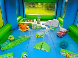 A soft play inflatable arena featuring colorful toys and a small car for children to enjoy.
