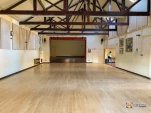 Stage area in main hall with wooden beams.