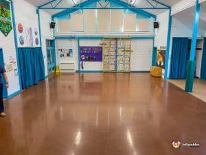 Empty hall with hard floor and high celling beams.