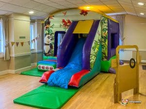 Jungle Bouncy castle with a low slide and animal artwork.