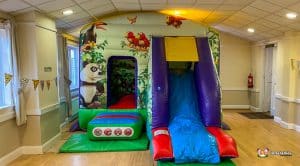 Low front slide bouncy castle with jungle animals theme.