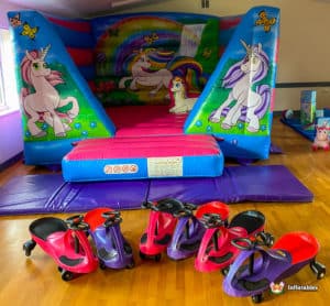 Low bouncy castle with unicorn theme and plasma cars.