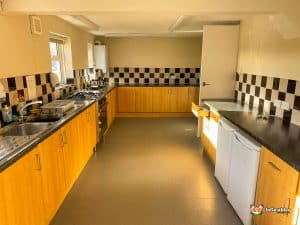 Kitchen with oven, sinks and black and white tiles.