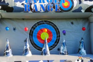 A colorful target range featuring a bullseye target with colored balls and camouflage cones in an inflatable setup.