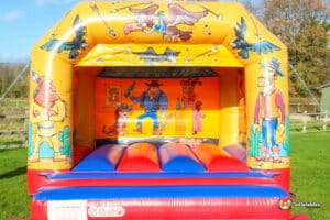 Western-themed bouncy castle featuring colorful cartoon characters, inviting children to play and have fun