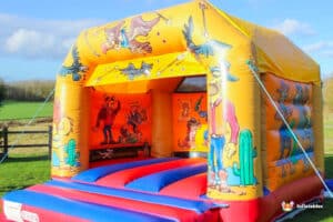 A vibrant Western-themed bouncy castle adorned with playful cartoon characters, perfect for children's entertainment.