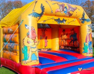 Cartoon characters decorate a lively Western-themed bouncy castle, creating a fun atmosphere for kids to enjoy.