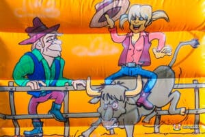 Cartoon characters decorate a lively Western-themed bouncy castle.
