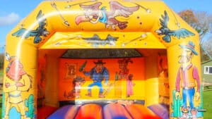 A cheerful Western-themed bouncy castle with colorful cartoon characters, designed for children's play and enjoyment.