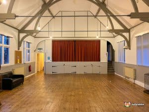 empty venue with stage and hardwood flooring