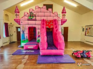 Pink Bouncy castle with matching plasma cars and purple mats
