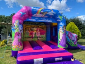 A vibrant unicorn-themed bouncy castle adorned with princess graphics, inviting children to jump and have fun.