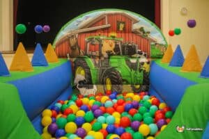 A playful air juggler ball pool with charming farm animals and a barn, designed for an entertaining and safe playtime experience.