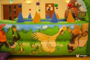 A lively air juggler ball pool adorned with friendly farm animals and a barn, offering a joyful atmosphere for young children.