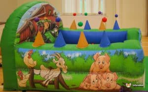 A vibrant air juggler ball pool surrounded by cheerful farm animals and a barn, creating a lively play environment for kids.