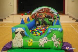 A cheerful farm-themed ball pit brimming with colorful balls, ideal for engaging air juggler play.