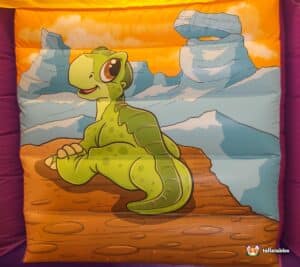 A whimsical bouncy castle featuring dinosaurs and animals, designed for children's amusement and active play.