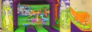 A vibrant bouncy castle adorned with dinosaur print.