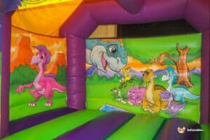 A cheerful bouncy castle decorated with dinosaurs and animals, providing a playful space for children to enjoy.