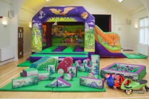 1. A large indoor play area featuring a bouncy castle and various toys for children to enjoy and play safely.