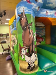 Farm animal themed bouncy castle with fun animals in bright colours.