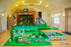 A vibrant play area featuring a farm-themed inflatable and various soft toys for children to enjoy