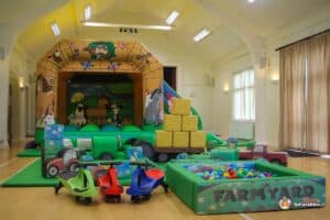 A lively play area with a farm theme, including a barn, playful animals, and colorful equipment for children's enjoyment.
