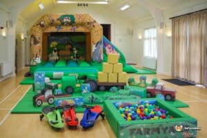 A playful farm-themed area for kids, complete with a barn, animal figures, and various colorful play equipment.