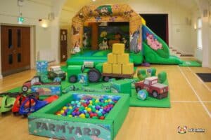 A children's play area designed with a farm theme, showcasing a barn, farm animals, and engaging play structures.