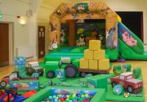 A vibrant play area featuring farm-themed structures, including a barn, animals, and colorful play equipment for children.