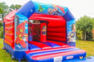 A superhero-themed bouncy castle named "Hero Biff and Bash," featuring vibrant colors and playful designs.