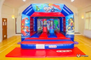 A colorful superhero-themed bouncy castle with vibrant graphics and a fun design, inviting children to play and jump.