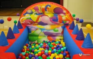 A cheerful bouncy castle featuring balloons and decorations, providing a fun play area for children at a festive event.