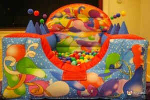 A colorful bouncy castle adorned with balloons and festive decorations, inviting children to play and enjoy.