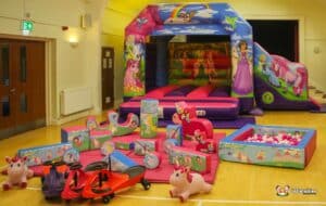 A vibrant inflatable slide featuring princesses and a pink unicorn, designed for children's play, with colorful graphics and a fun theme.