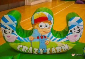 A large inflatable farm animal displaying the words "Crazy Farm," part of a soft play area for children.