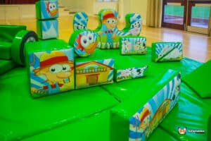 A large soft play area featuring colorful toys and a ball pit, designed for children's fun and safe play.