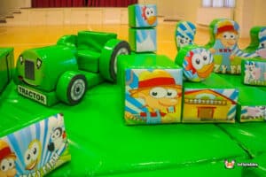 A spacious soft play area filled with vibrant toys and a ball pit, providing a safe environment for children to play.