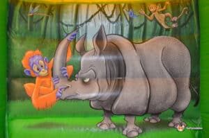 Bouncy castle with a lively jungle theme, decorated with colorful animals, providing a fun play area for children.