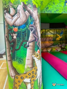 A colorful bouncy castle designed with a jungle theme.
