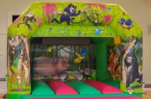 Jungle-themed bouncy castle featuring vibrant colors and animal designs, inviting children to play and explore