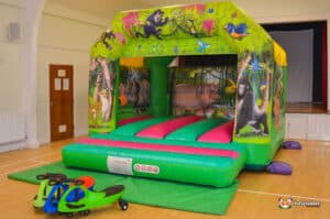 Jungle-themed bouncy castle, adorned with bright colors and animal motifs, perfect for children's outdoor fun.